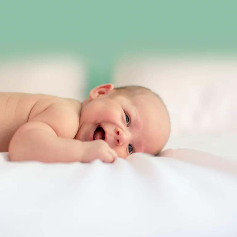 bébé qui sourit sur le ventre