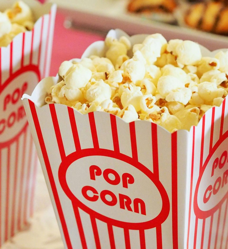 Close-up of gourmet popcorn in classic red and white striped boxes, perfect cinema snack.